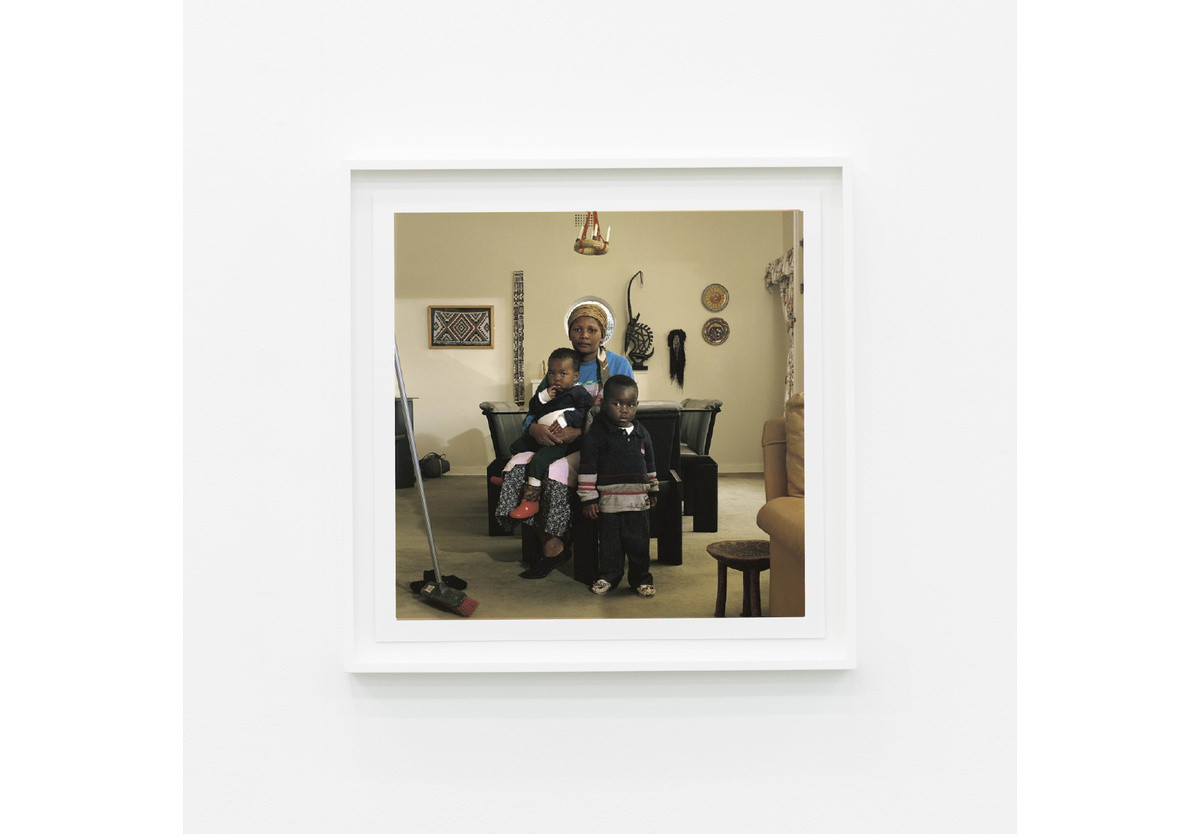 David Goldblatt - Victoria Cobokana, housekeeper, in her employer’s dining room with her son Sifiso and daughter Onica, Johannesburg, June 1999. Victoria died of AIDS on 13 December 1999, Sifiso died of AIDS on 12 January 2000, Onica died of AIDS in May 2000, 1999